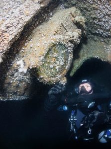 GUE diver Grahame Blackmore inspects one of the rare tropical portholes still firmly bolted to the wreck of Warrior II.