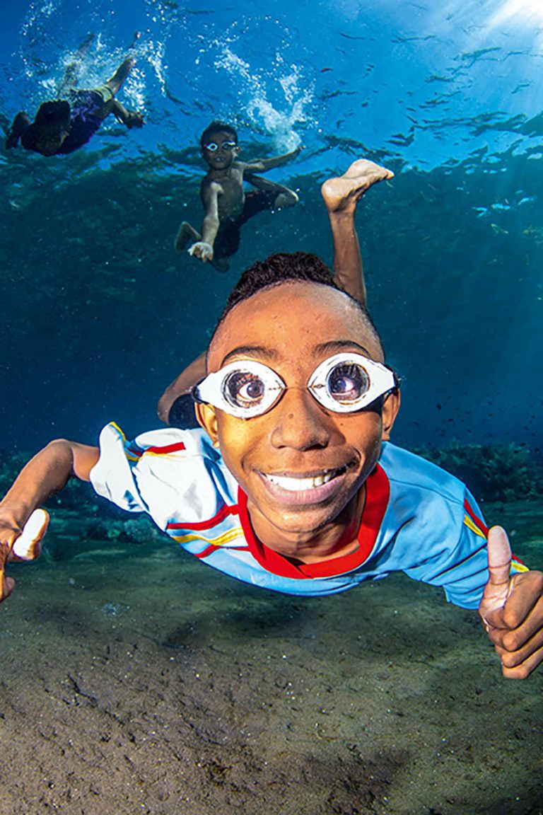 A boy freediving in Alor with his home-made goggles.