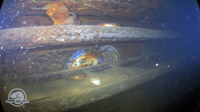 Plates and other artefacts on shelves beside a mess table where the crew would have eaten. (Picture: Parks Canada Underwater Archaeology Team)