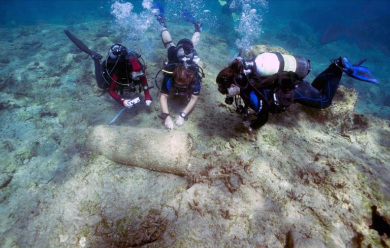 Divers examine the granite pillar. (Picture: Department of Antiquities)