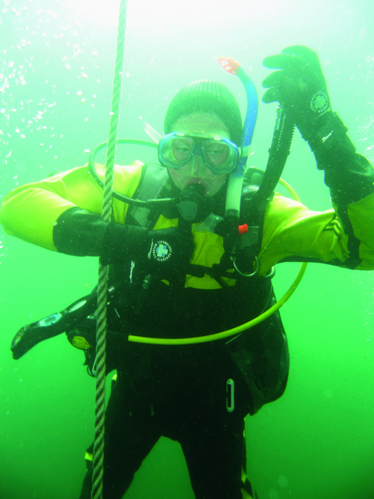 Diver operating drysuit valve staying close to line