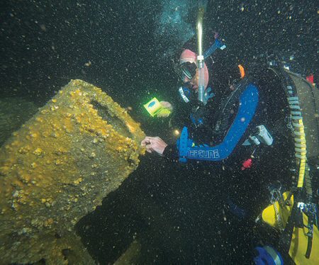 Rob Graafsma at the foundation for a gun-mount, exposed where cladding for the conning tower has broken away or decayed