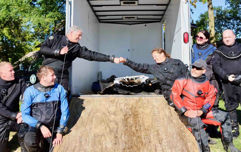 Archaeologists James Skibo and Tamara Thomsen bump fists after raising the 3,000-year-old canoe last year (WHS)