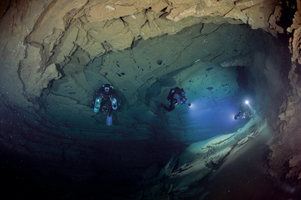 Extreme Underwater Filming: Lighting Challenges in Caves, Mines, and Deep Wrecks 3 Extreme underwater filming in a dark cave with divers using specialised lights and rebreathers