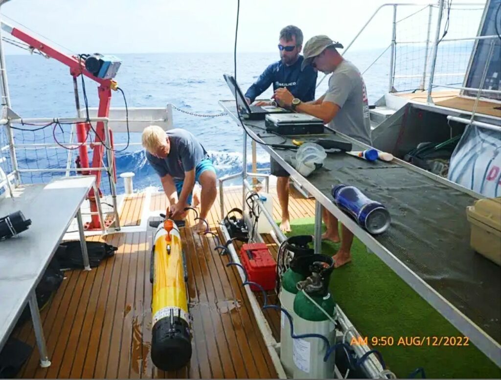 Mark Moline rinses the AUV while Matthew Breece and Erik White download and analyse the data