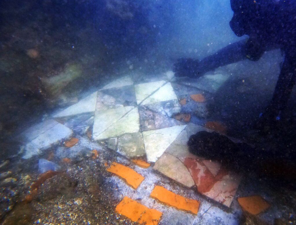 Piso con triángulos de mármol blanco y negro intercalados con Portosanto (Nauma