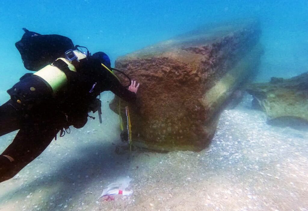 Diver with one of the columns found at the wreck site (Israel Antiquities Authority)