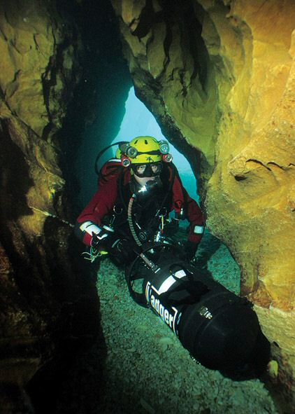 Diver Rob Dalby negotiates the restriction at the entrance to the cave. Beyond here, the passage is much bigger.
