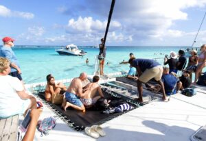 Des milliers de visiteurs nagent sur le banc de sable pour participer à l'expérience Stingray City, s'enduisant d'huile solaire avant de se lancer. La plupart des crèmes solaires commerciales sont toxiques pour les coraux.