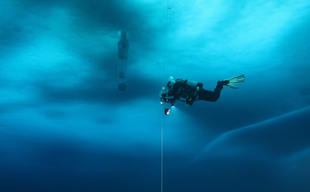 Moran kiinnittää tutkimuslaitteita sukelluslinjaan sukellusreiän alla (S Rupp)