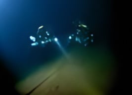 Divers hovering over the landing deck of the Graf Zeppelin WWII aircraft carrier wreck