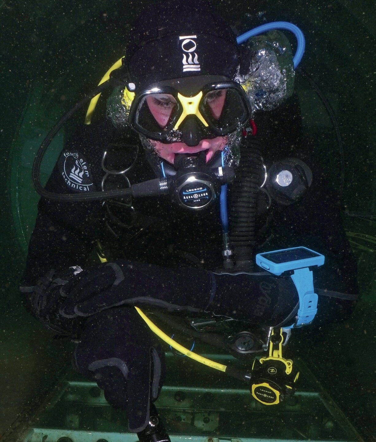 Scubapro Luna 2.0 AI dive computer on diver’s forearm over drysuit sleeve.