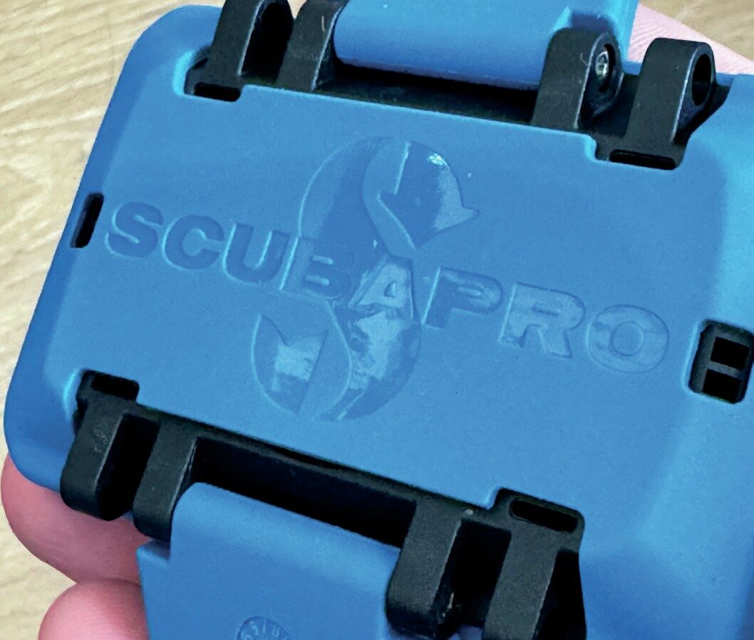 Back of Scubapro Luna 2.0 AI dive computer with blue protective cover highlighting slim profile and durable build.