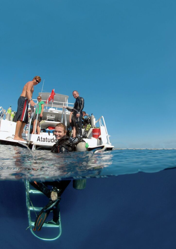 Shore Diving Cayman Brac: The Ultimate Guide to the Caribbean’s Best Dive Sites 7 A diver exiting the water onto one of the many great dive boats around Cayman Brac