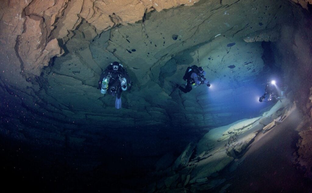 Divers filming in Ojamo lime mine with professional lighting
