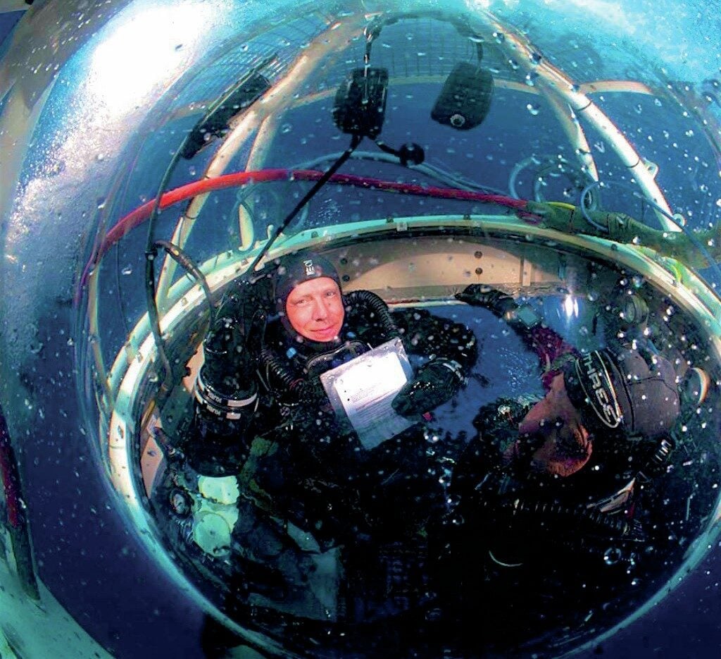 Divers recovering inside underwater habitat after deep filming dive