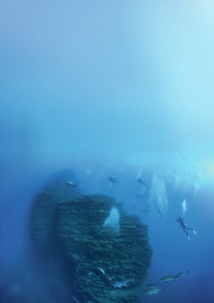 Divers exploring The Boiler dive site with manta rays at Socorro Island