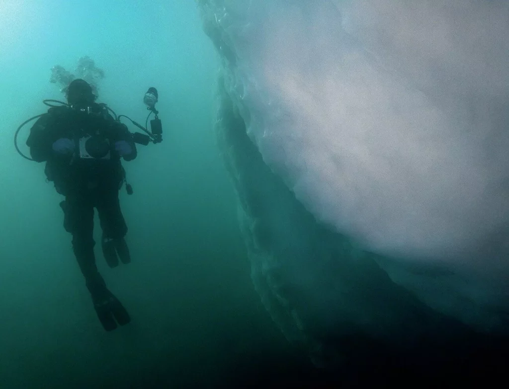 Iceberg Diving in Greenland: Beauty, Danger and Essential Safety Protocols 7 Iceberg diving in Greenland showing diver beneath massive glacier ice