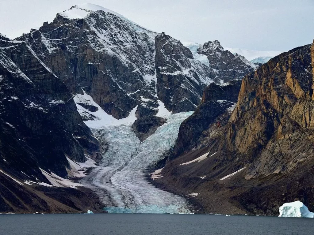 Iceberg Diving in Greenland: Beauty, Danger and Essential Safety Protocols 1 A glacier tumbling to the sea in Greenland’s Scorsbysund region