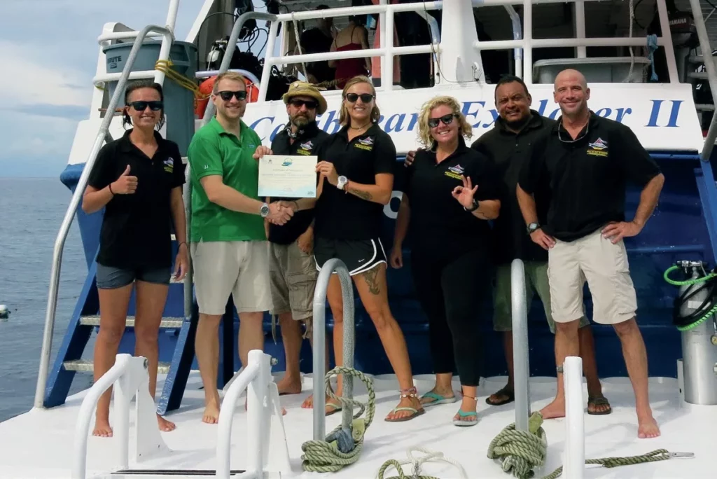 Diving Saba and St Kitts: Pinnacles, Wrecks, and Volcanic Wonders 12 The crew of Explorer Ventures receiving their Green Fins certification for sustainable diving practices.
