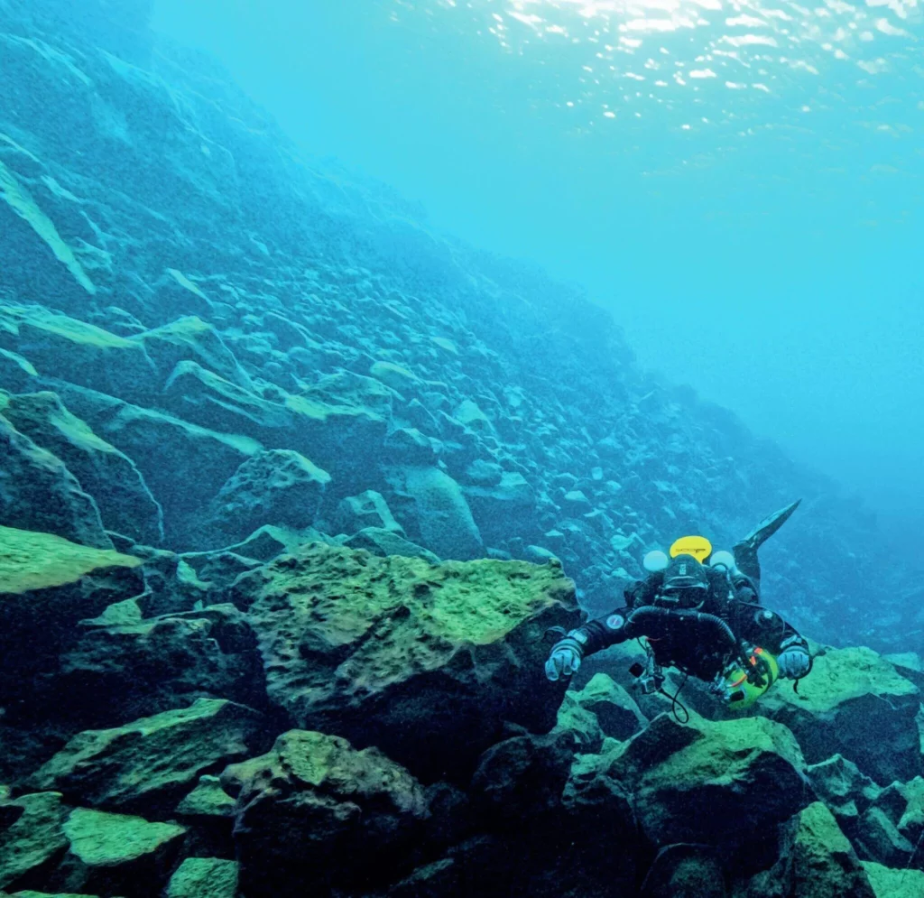 Iceland’s Underwater Frontier: Science in Silfra 9 Scuba divers descending into the luminous blue water of the Silfra fissure between the North American and Eurasian tectonic plates.