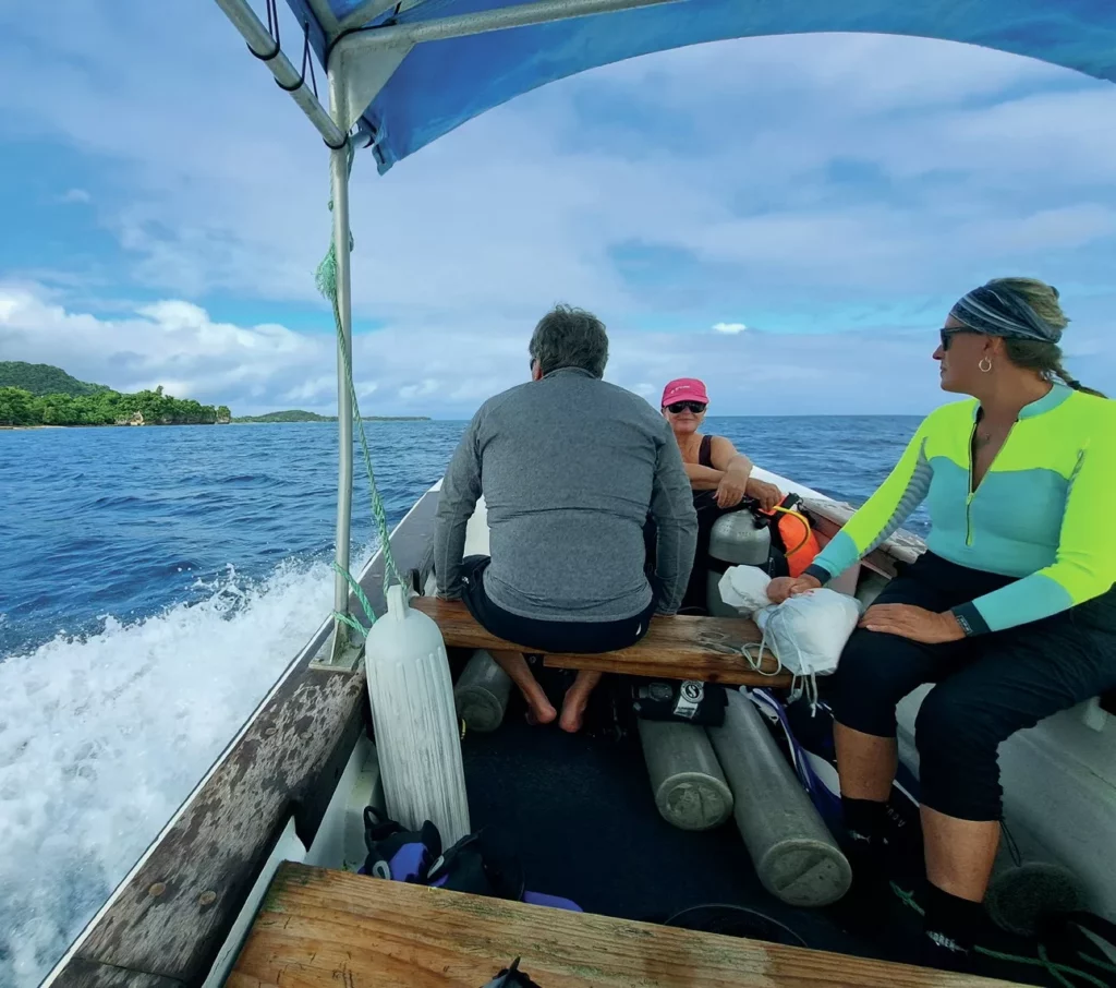 Divers departing for a day of diving Port Vila Vanuatu on a Big Blue boat to explore the coral reefs of Mele Bay.