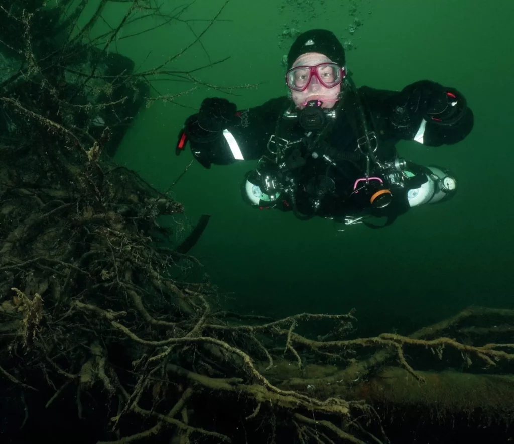 A scuba diver fully equipped for cold water diving, highlighting the importance of functional gear in challenging underwater environments.