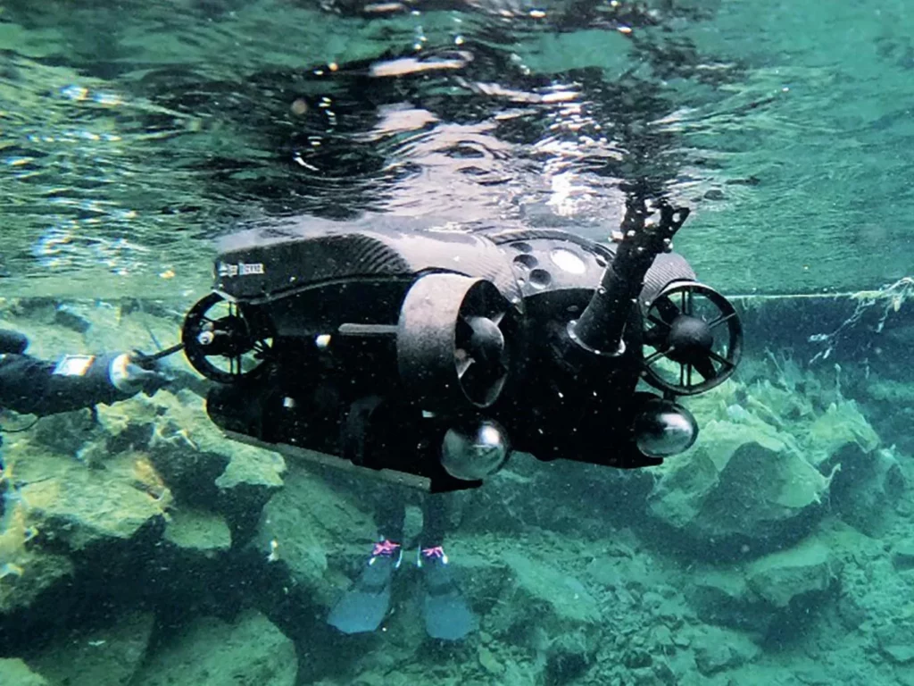 Iceland’s Underwater Frontier: Science in Silfra 4 A Deep Trekker ROV being deployed in the Silfra Hellir headpool for underwater exploration.
