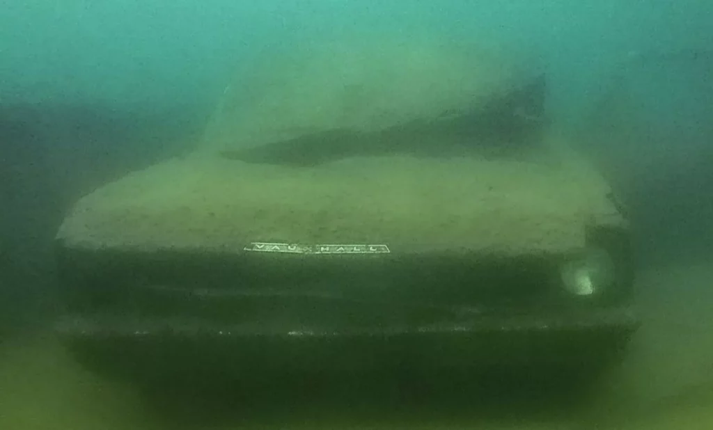The ghostly remains of a Vauxhall Cresta car sitting on the submerged Lowburn Bridge in the murky freshwater of Lake Dunstan, New Zealand.