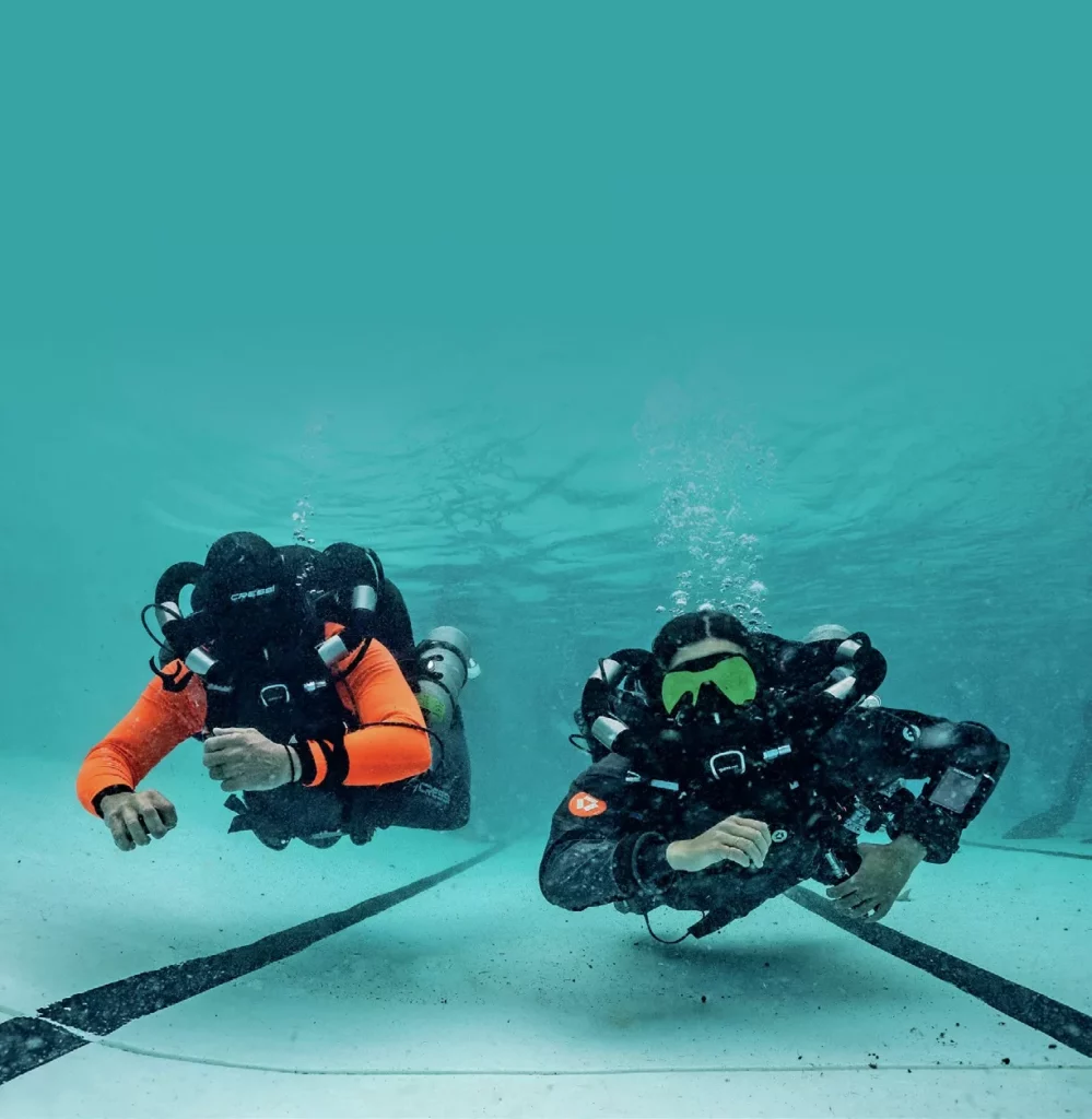 Divers testing rebreather units during a technical diving pool session at Manta Lodge.