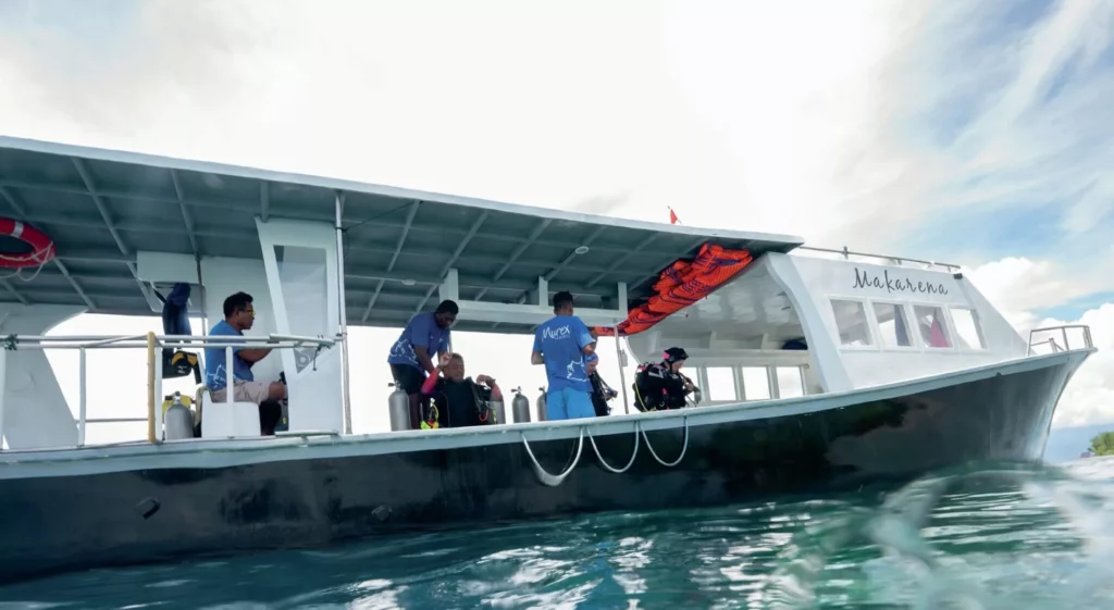 Scuba divers preparing their gear on a spacious Murex Resorts dive boat.