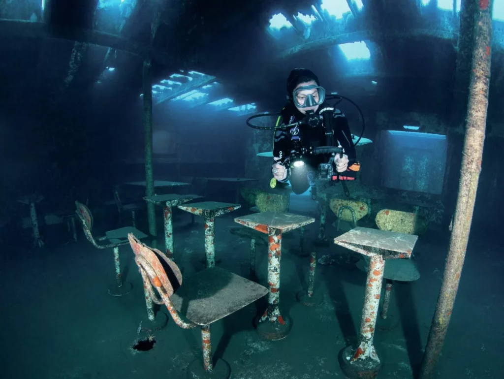 Divers exploring the interior galley area of a technical wreck dive in Madeira’s marine park.