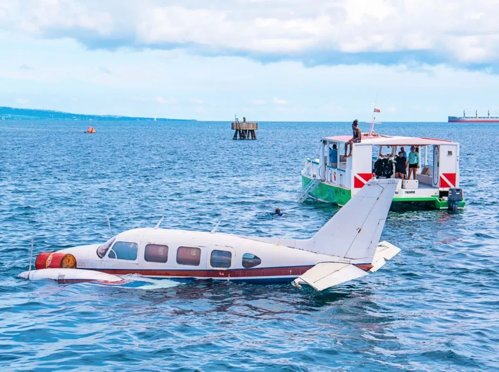 Piper Navajo plane beside the Kenneth's Dive Centre boat