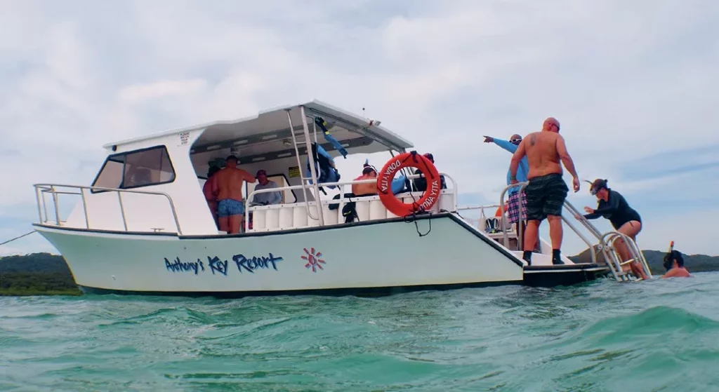 Happy travelers returning to the boat after a day of family snorkeling adventures at Anthony's Key Resort in Roatan.