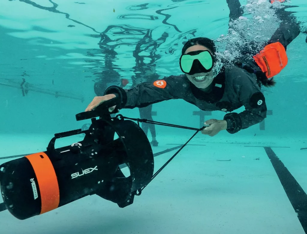 A diver using a Suex VR underwater scooter (DPV) in a swimming pool during a tech diving workshop.
