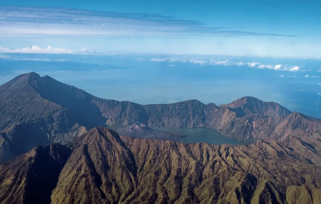 Aerial perspective of the massive Mount Rinjani volcano on Lombok island captured from a plane window en route to Wakatobi.